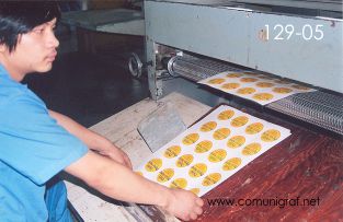Foto 129-05 - Empleado laminando pliegos de etiquetas impresas en la planta de Shanghai Xinya Printing Co Ltd de Wenzhou, Shanghai China - 13-Junio-2006