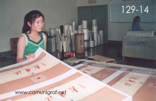 Foto 129-14 - Empleada atendiendo el control de calidad de los acabados laminados de impresos con pélícula transparente en la planta de Shanghai Xinya Printing Co Ltd de Wenzhou, Shanghai China - 13-Junio-2006
