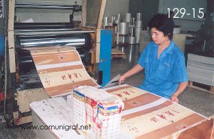 Foto 129-15 - Empleado laminando acabados de impresos con pélícula transparente en la planta de Shanghai Xinya Printing Co Ltd de Wenzhou, Shanghai China - 13-Junio-2006