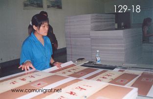 Foto 129-18 - Señorita revisando la calidad de los impresos laminados en la planta de Shanghai Xinya Printing Co Ltd de Wenzhou, Shanghai China - 13-Junio-2006