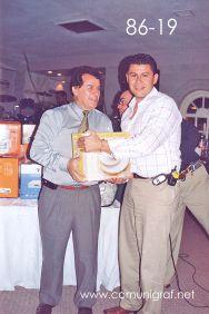 Foto 86-19 - Feliz afortunado con un paquete de platos de cerámica, lo entrega el Ing. Fco. Javier Navarro (izq) en la tradicional Comida Baile del día del Impresor de Canagraf Guanajuato, realizada el 24 de Septiembre 2005 en el Hotel La Nueva Estancia de la Ciudad de León, Guanajuato México.