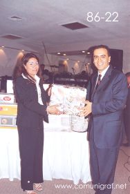 Foto 86-22 - Feliz afortunado de un regalo sorpresa, lo entrega Delia Hernández (izq) en la tradicional Comida Baile del día del Impresor de Canagraf Guanajuato, realizada el 24 de Septiembre 2005 en el Hotel La Nueva Estancia de la Ciudad de León, Guanajuato México.