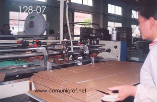 Foto 128-07 - Empleada introduciendo las cajas impresas y suajadas a la máquina dobladora en la empresa Shanghai Jinan Pack Co. Ltd en Shanghai, China - 13-Junio-2006