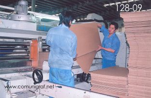 Foto 128-09 - Empleados introduciendo láminas de cartón corrugado a una Máquina SRPACK las cuales se convertirán en cajas debidamente impresas y suajadas en la empresa Shanghai Jinan Pack Co. Ltd en Shanghai, China - 13-Junio-2006