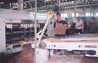 Foto 128-12 - Empleado revisando que las impresiones y suajados de cajas de cartón corrugado salgan correctamente de una Máquina SRPACK en la empresa Shanghai Jinan Pack Co. Ltd en Shanghai, China - 13-Junio-2006
