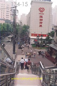 Foto 134-15 - Bajando las escaleras del puente peatonal y al frente el Huilian Commercial Building sobre la avenida Tianyaoqiao de Shanghai China - 16-Junio-2006