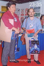 Foto 23-35 - En el stand de la Revista Comunigraf, Martín López Castañeda y persona no identificada en la Expo Artes Gráficas León 2003 en el Poliforum de la ciudad de León, Gto. México.