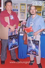 Foto 23-36 - Martín López Castañeda con persona no identificada en el stand de la Revista Comunigraf en la Expo Artes Gráficas León 2003 en el Poliforum de la ciudad de León, Gto. México.